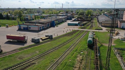 A railway line leading to a large oil refinery. Oil tanks on the railway tracks.