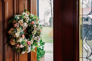 Fototapeta premium Decorative wreaths displayed on wall, seasonal and festive home decorations for interior design, holiday styling, and handmade floral ornament concepts