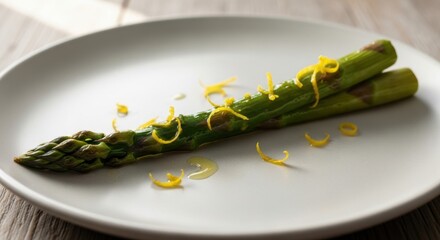 Single asparagus spear with lemon zest on a white plate