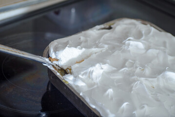 Homemade Cremeschnitte in a pan made and a knife that cuts a piece of cake.