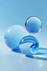 Three translucent blue spheres rest on a light blue surface, creating a minimalist, serene composition with subtle reflections and light interplay