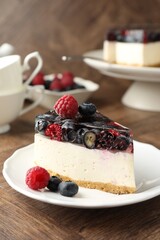 Piece of delicious cheesecake with berries on wooden table, closeup