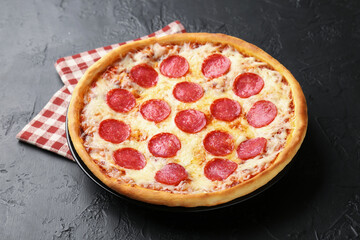 Delicious pepperoni pizza on black background, closeup