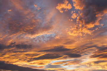 夕焼け、雲に差し込むオレンジ光