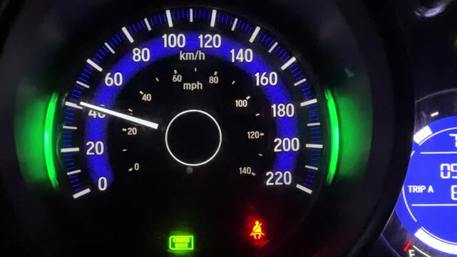 Car speedometer and dashboard gauges illuminated at night, showing the vehicle&rsquo;s performance display and dashboard indicators, symbolizing technology, precision, and automotive design.
