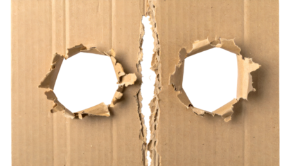 Close-up of torn cardboard showing two holes and a slit, revealing emptiness