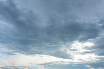 Obraz premium Overcast gray sky dominated by thick stormy clouds with bright light breaking through the bottom area