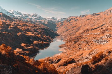 High-angle view of a serene alpine lake nestled in a valley of vibrant autumn hues