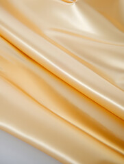 Golden silk fabric with soft folds and shimmering texture creating a luxurious background