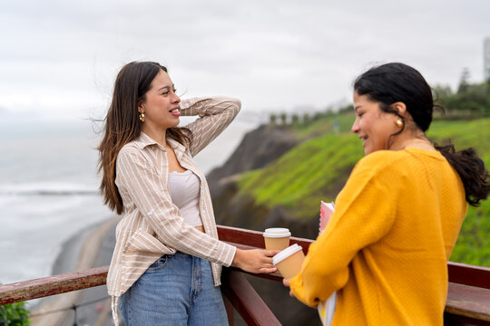 College students discussing notes and enjoying coffee outdoors - Powered by Adobe