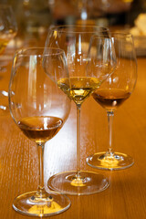 A Spectrum of Taste: a photograph of a wine tasting setup featuring multiple wine glasses arranged in a line on a warm wooden table. 