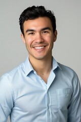 A man in a blue shirt smiles at