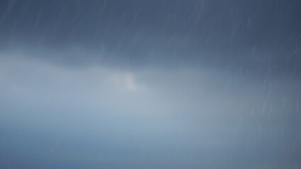 Heavy rain falling from the sky with dark clouds creating a dramatic atmosphere outside