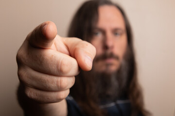 A man with a beard pointing at something