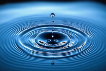 Close-up of a water droplet creating concentric ripples on a smooth blue water surface, capturing clarity and calmness in motion