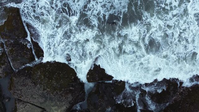 Close-up Aerial View of Waves Breaking Against Rocky Shore, Majestic Nature Background