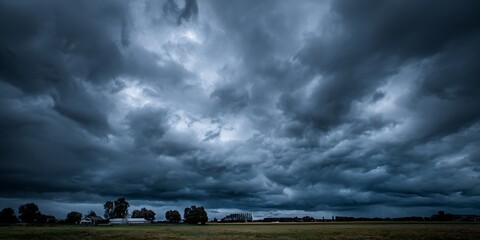Dramatic storm clouds gather ominously over a rural landscape, hinting at approaching weather changes and raw natural power.