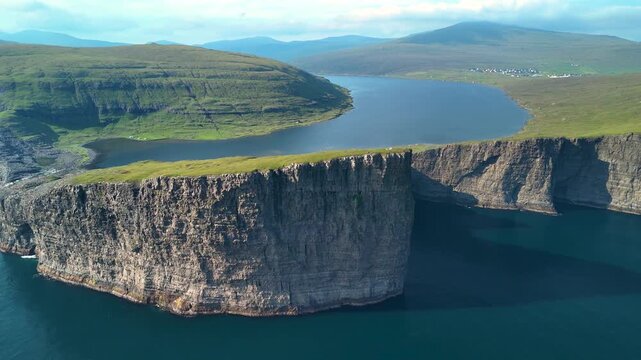 A breathtaking panorama of Lake Sorvagsvatn, showcasing its dramatic cliffs and lush greenery. Captured during a bright day, the tranquility of the Faroe Islands shines through.