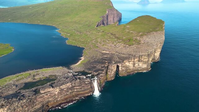 Explore the stunning landscape around Lake Sorvagsvatn, where cliffs rise dramatically above the shimmering sea, showcasing the natural beauty of the Faroe Islands under bright sunlight.