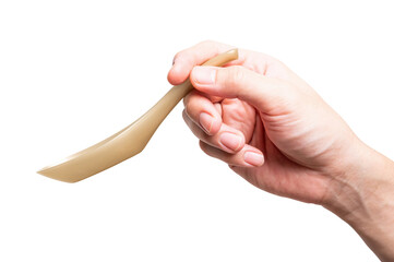 Male hand holding a gold plastic spoon isolated on white background.