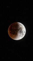Ethereal spectacle of a partially eclipsed moon amidst a starry expanse in the night sky
