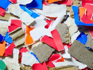 Multicolored poster paper, torn into numerous pieces.