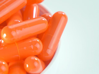 Many orange capsules on a white background.