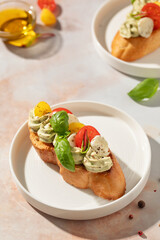 Caprese toasts or bruschetta with mini mozzarella cheese, cherry tomato and basil.