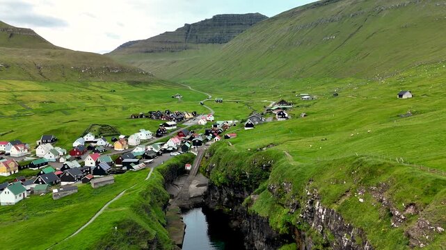 Experience the breathtaking beauty of Gjogv village, Faroe Islands, where a quaint village rests amidst lush green hills and unique geological formations. Natures splendor captivates all.