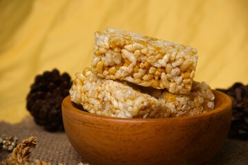 Crispy Jipang (Bipang) sweet rice crackers served in a wooden bowl on burlap with rustic natural decor, perfect for snack themes.