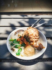 Close up of a jumbo meatballs with rice noodle soup, served with bean sprouts, green vegetables and pieces of beef cartilage