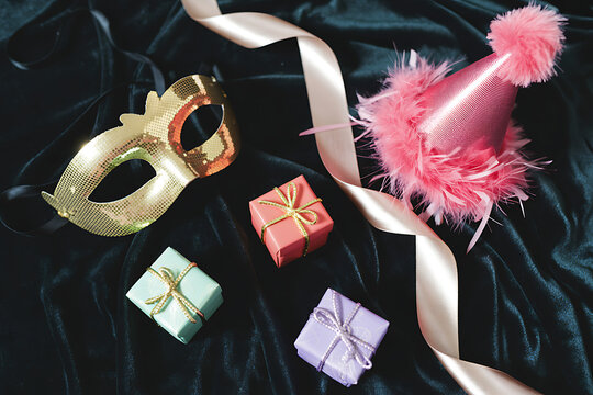 Sparkling masquerade mask, festive party hat, and colorful gift boxes create a magical atmosphere for celebrations and surprise parties.