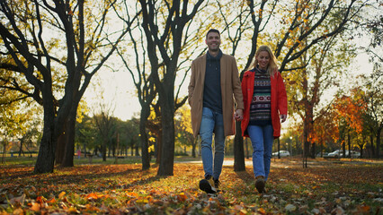 Couple walking in a park during autumn, enjoying a sunny day together