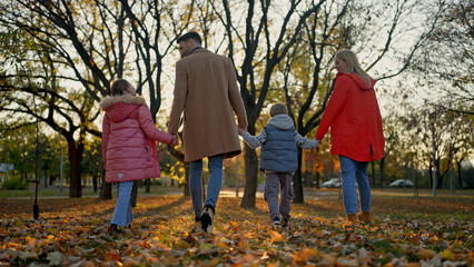 Family enjoying a walk in the park during the autumn season