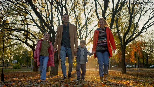 Family enjoying a walk in the park during the autumn season - Powered by Adobe