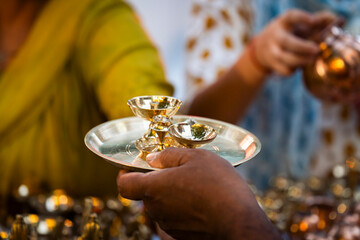 People shop for bronze and other metal items at a roadside stall on Dhanteras