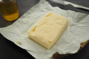 Fresh butter block on parchment paper with olive oil