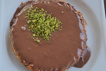 turkish kunefe topped with nuts and chocolate sauce