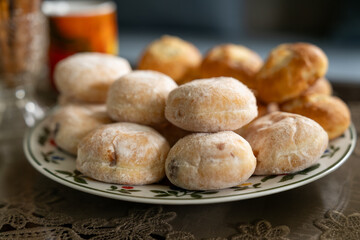 Detail of mini donuts with chocolate filling on a plate with pies in the background.
