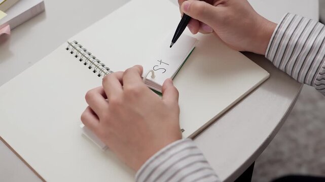 単語を覚えるアジア人男性の手元