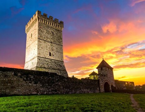 Medieval stone fortress with high tower and sunset sky - Powered by Adobe