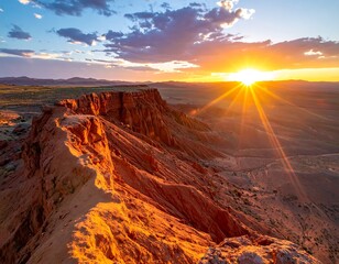 Majestic view of a red rock formation at sunrise with the sun's rays