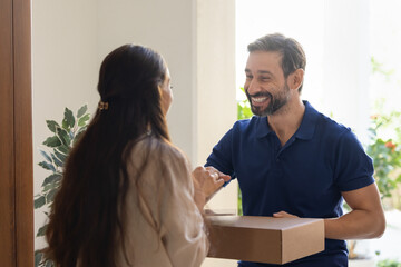 Smiling delivery man shaking hand with female client giving parcel