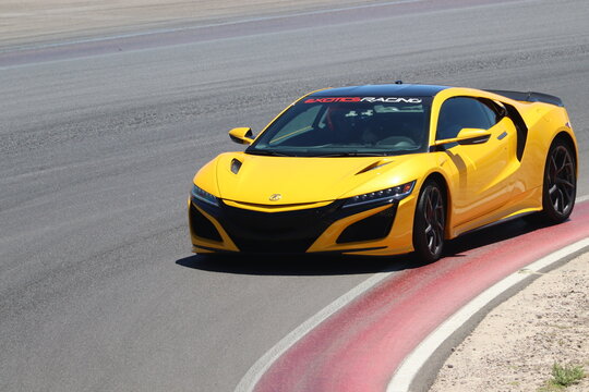 yellow Acura NSX on racetrack driving
