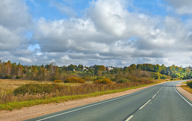 Country road through fields and forest cloudy day freedom of the road horizontal frame
