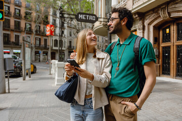 Obraz premium A man is talking and hugging a woman who is standing next to him and smiling while holding the phone