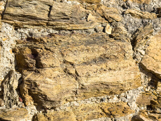 Close-up of weathered stone wall with rough texture