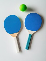Two blue ping-pong paddles and a green ball on a white background