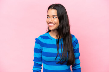 Fototapeta premium Young Colombian woman isolated on pink background looking side