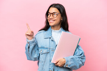 Young student Colombian woman isolated on pink background pointing up a great idea